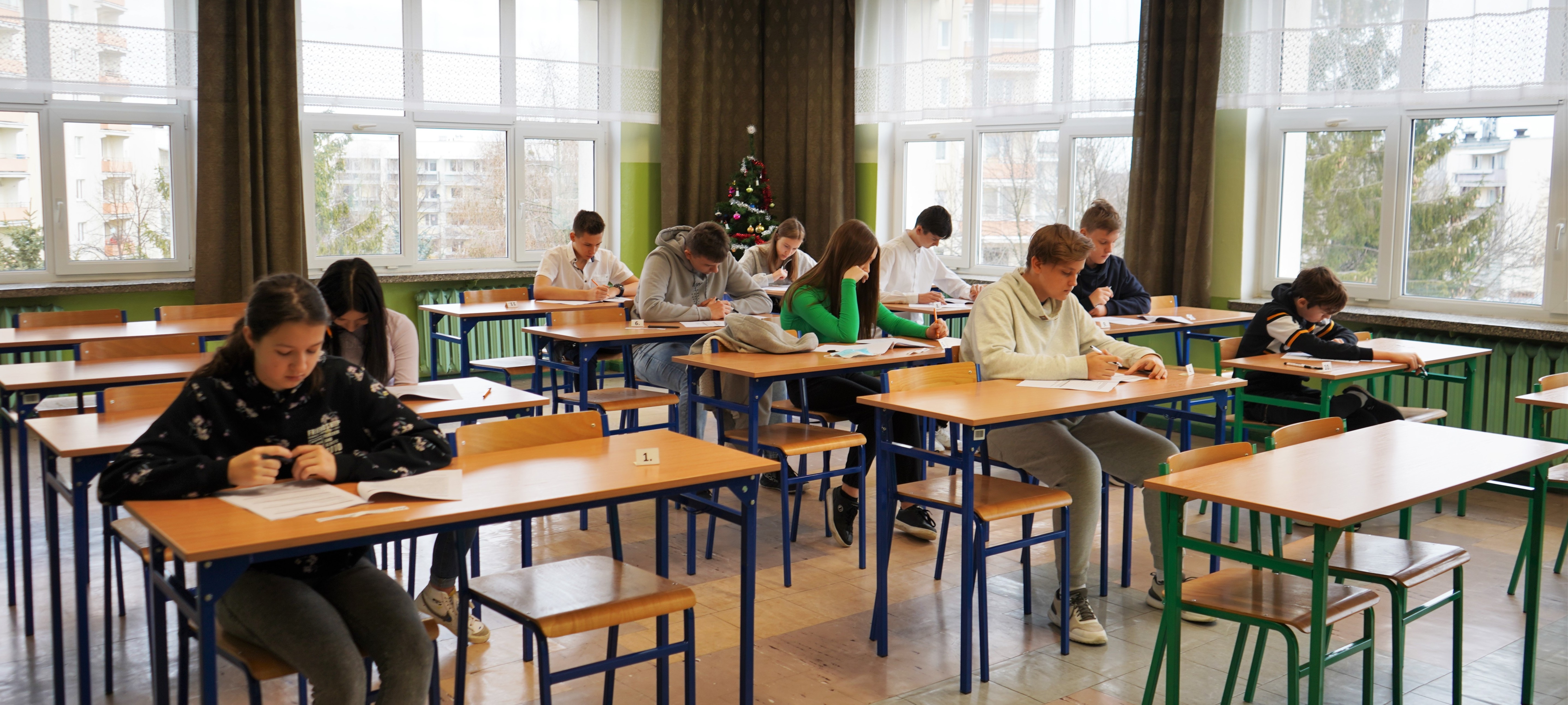 Uczniowie piszący egzamin w klasie.