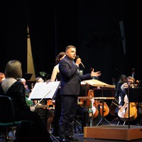 Na zdjęciu widac Prezydenta Miasta Puławy podczas przemówienia na scenie, wokół Prezydenta znajdują sie muzycy