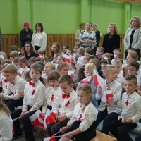 Grupa uczniów z biało-czerwonymi flagami