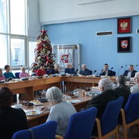 Prezydent Miasta Puławy z emerytowanymi pracownikami Urzędu Miasta przy stole.