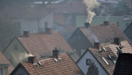 Dachy domów i dymiące kominy