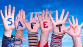 Zdjęcie dłoni dzieci z napisem ,,Safety" - bezpieczeństwo dzieci